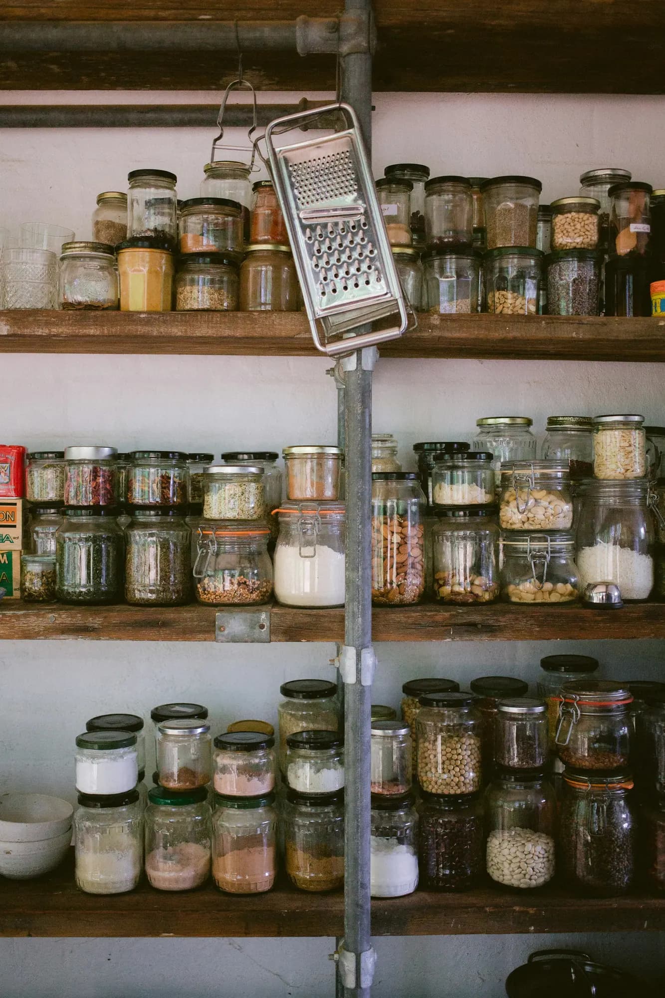 Glass jars of dry goods on open pantry shelves